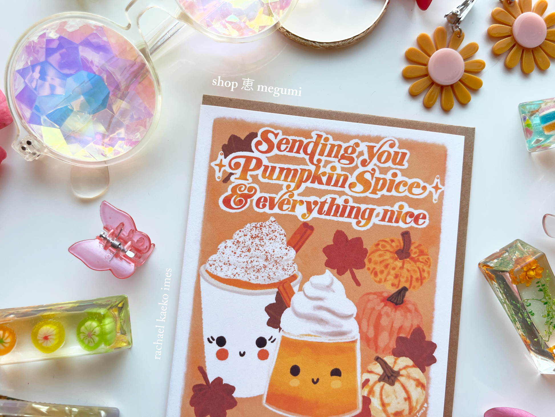 Fall-themed greeting card with cute PSL SZN pumpkin spice latte design and decorative items on a white surface