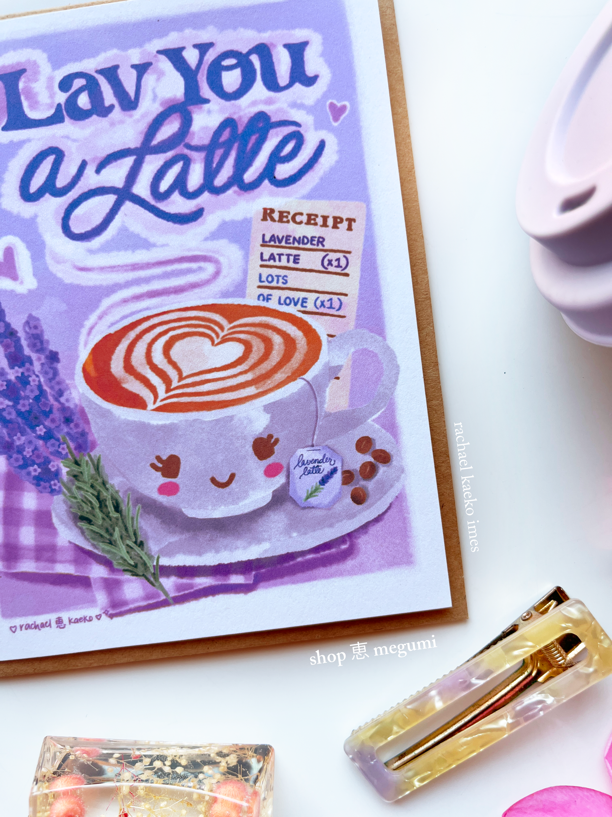 Close-up of a hand-illustrated greeting card with a kawaii coffee cup latte design and decorative items on a white background