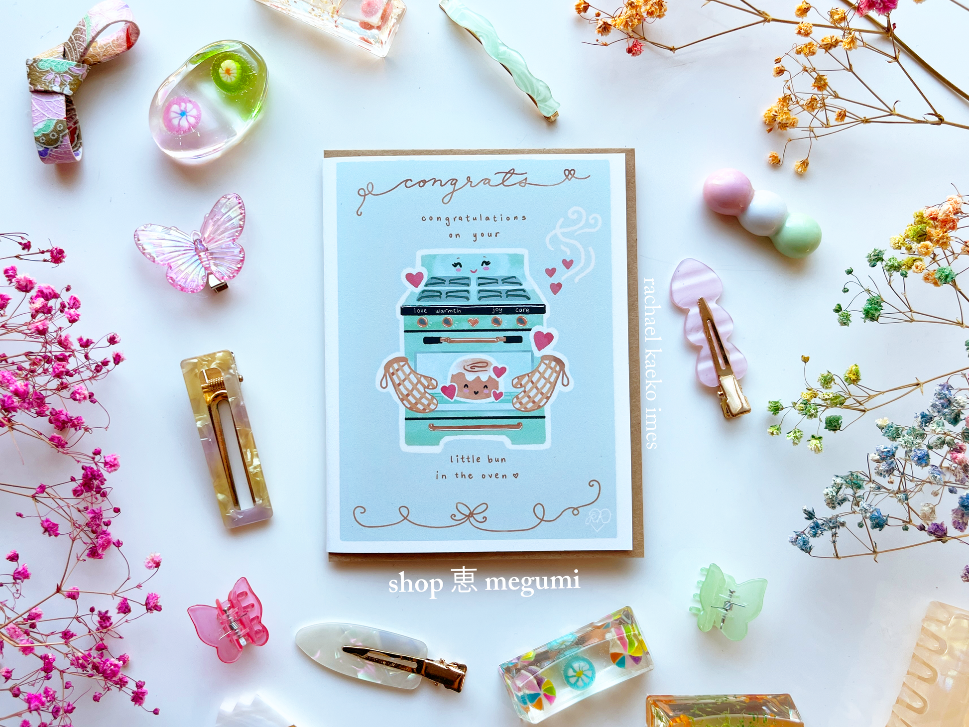 Kawaii greeting card with baby congratulations illustration surrounded by decorative items on a white background