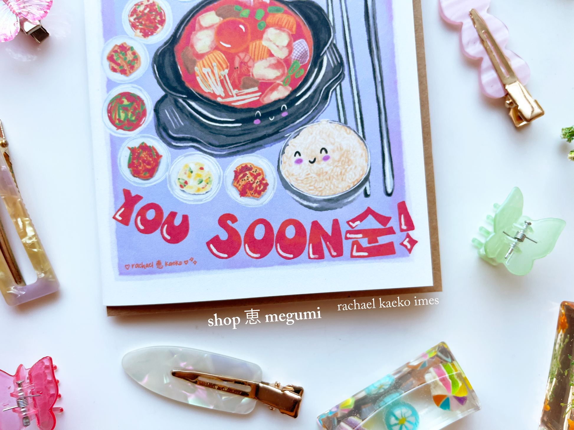 Kawaii greeting card with K food illustrations and text on a white background with decorative items.
