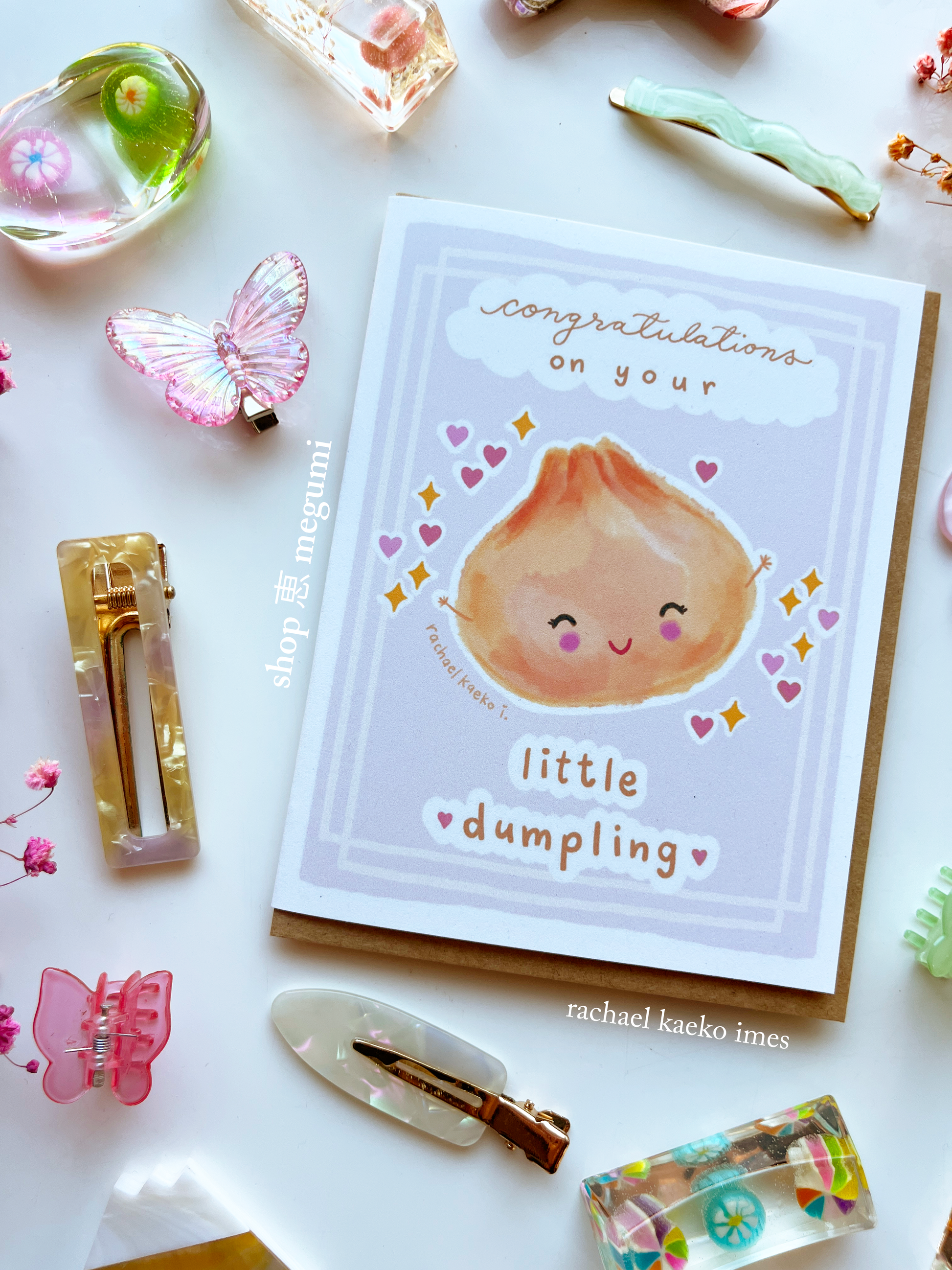 Cute baby shower greeting card with a cute illustration of a dumpling and text 'Congratulations on your little dumpling' on a decorative background.