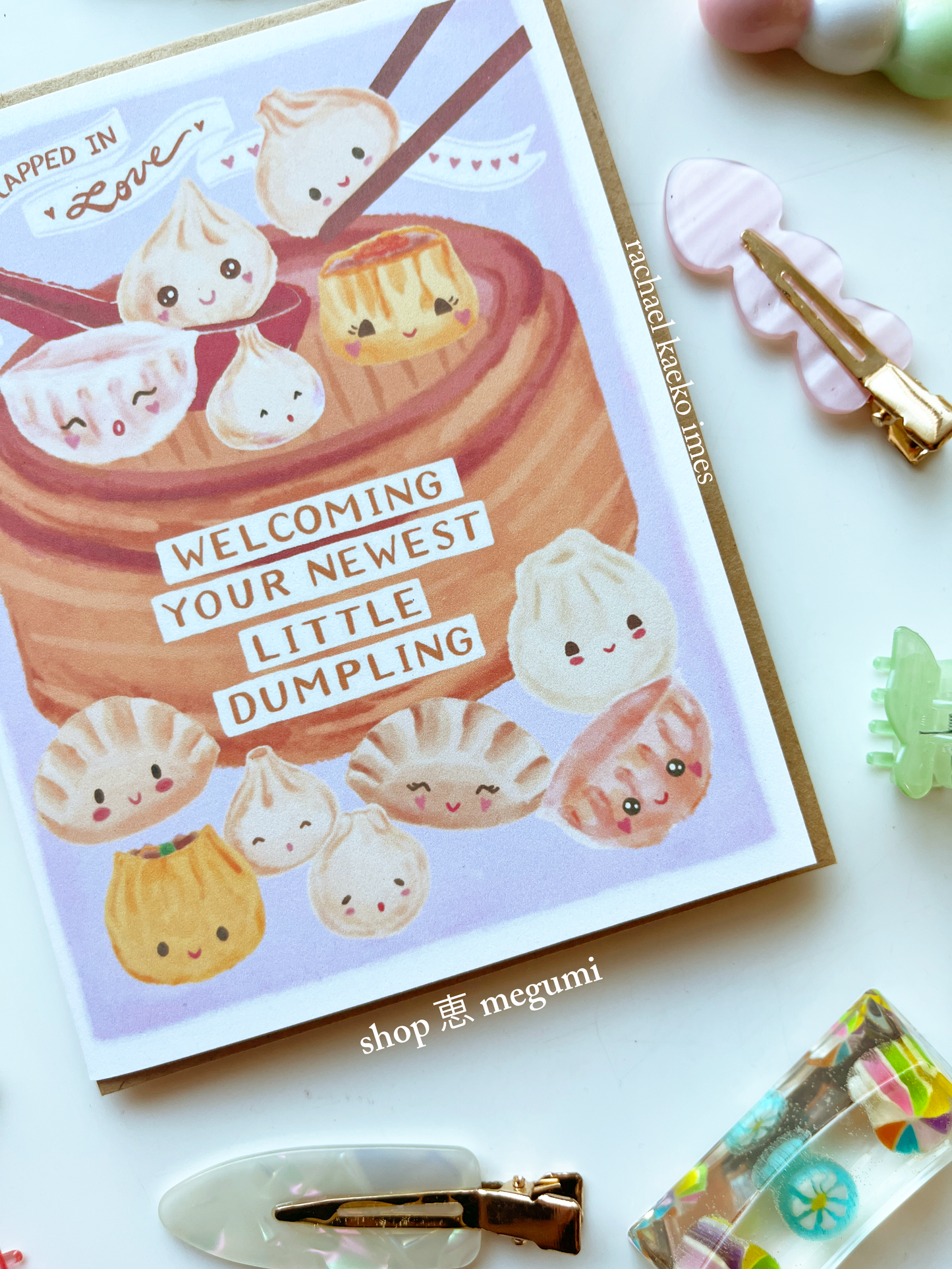 Cute greeting cards with kawaii dumpling illustrations and text on a white surface with colorful items.