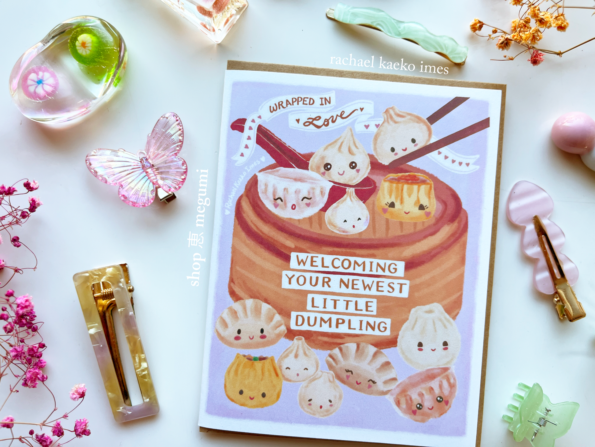 Cute Asian-themed baby shower card with kawaii dumpling illustrations on a white background with decorative items.