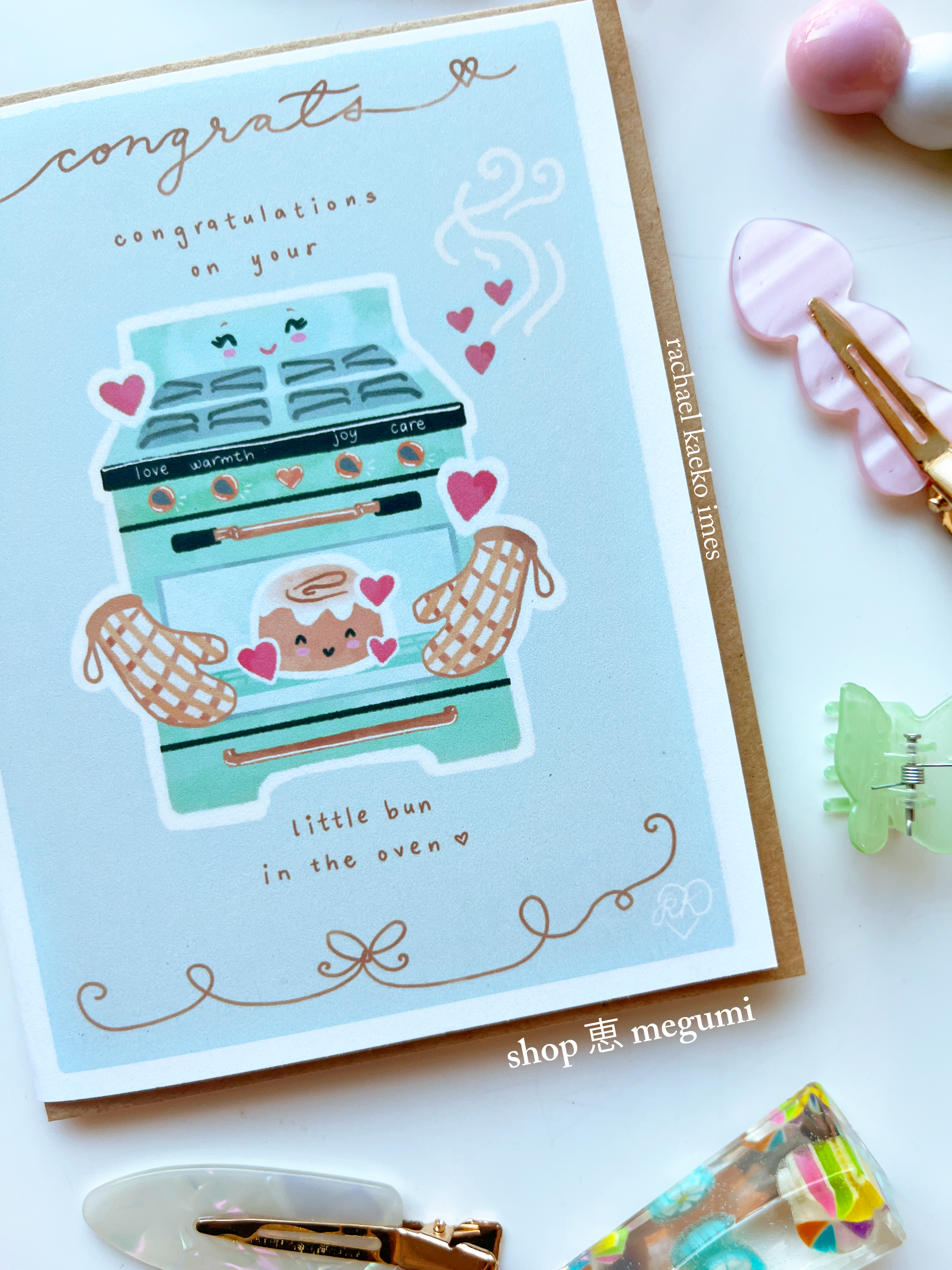 Cute baby shower card with a cute illustration of a baby bun in a mama oven on a white background.