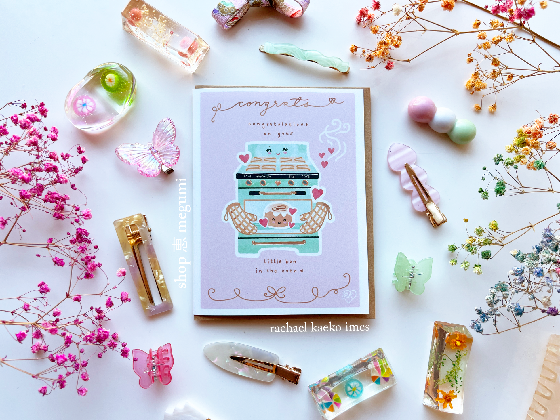 Cute baby shower congratulations card with "Congratulations on your little bun in the oven" text and cute smiling oven and cinnamon bun illustrations