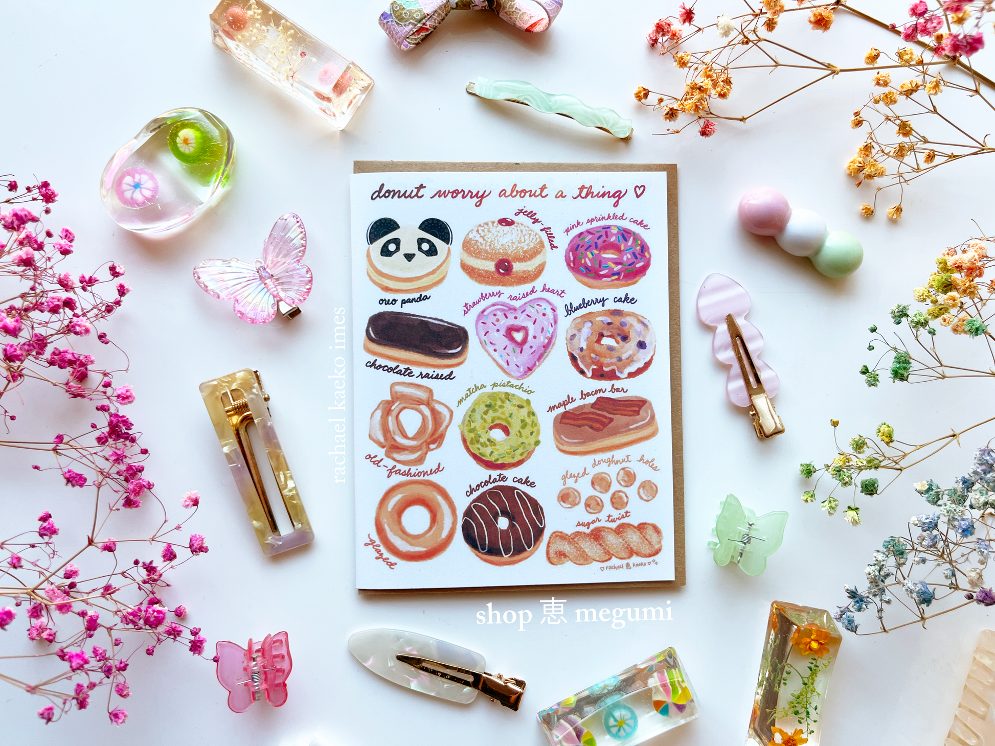 Cute donut shop greeting card with illustrations of donuts surrounded by decorative items on a white background