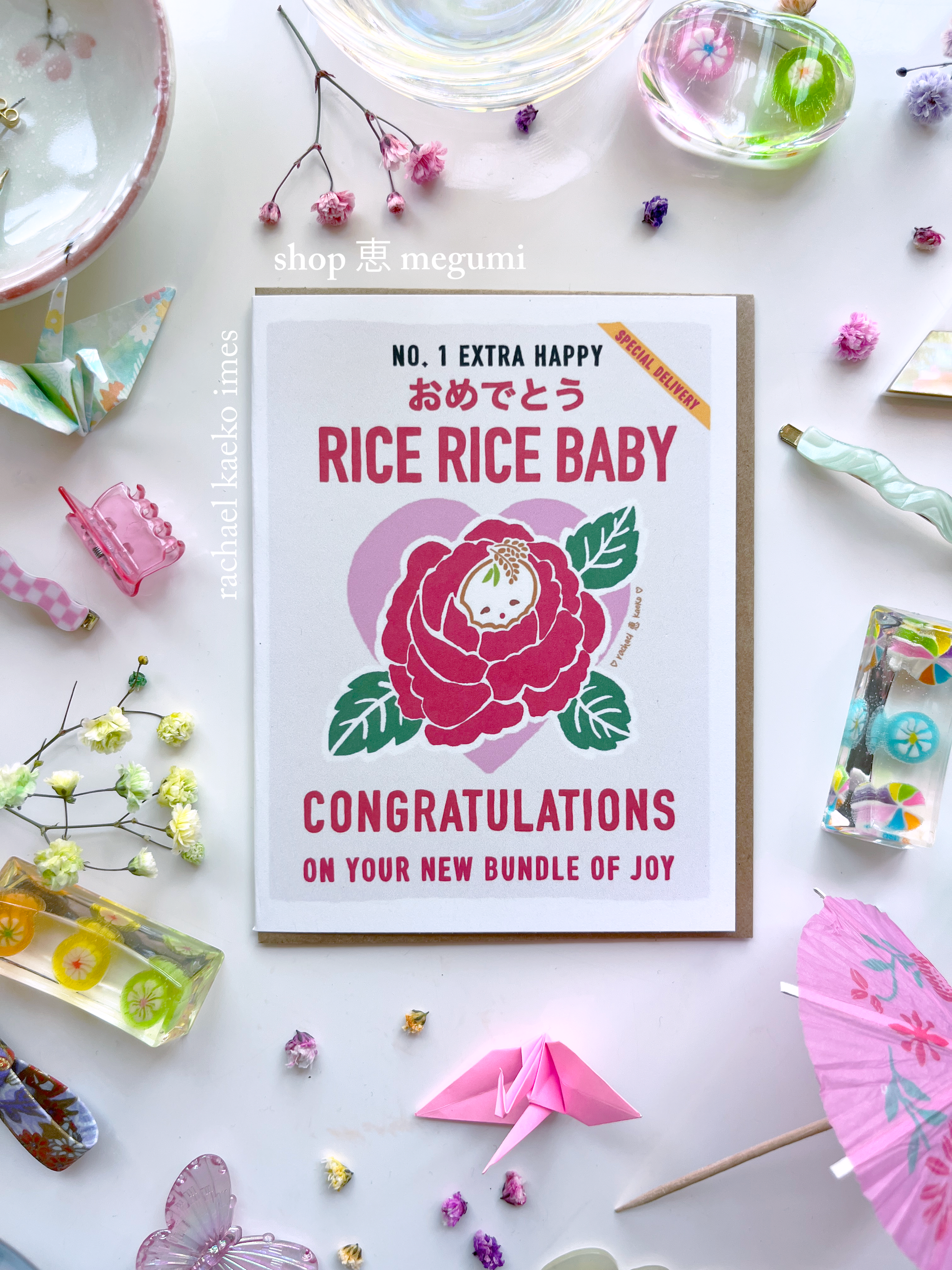 Baby shower card with illustrated floral rice bag design and text that reads "Rice Rice Baby, Congratulations on Your New Bundle of Joy" on a decorative background.